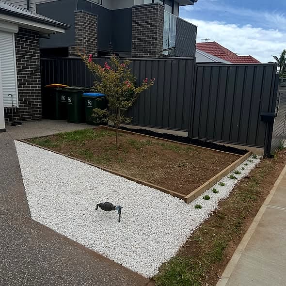 Backyard corner rebuilt with garden bed, pebbles and edging in Adelaide